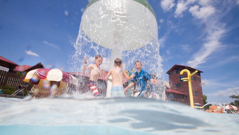 A water feature splashes kids with water at the Raccoon Lagoon outdoor area