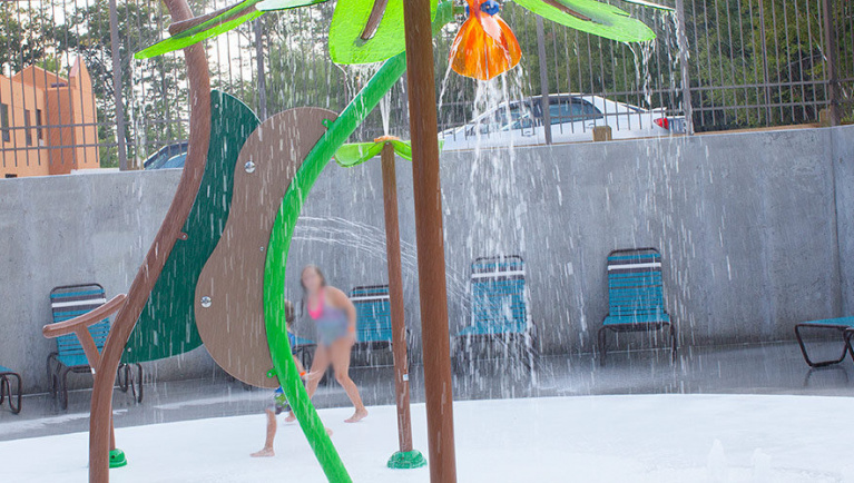 Kids play behind the outdoor water features 