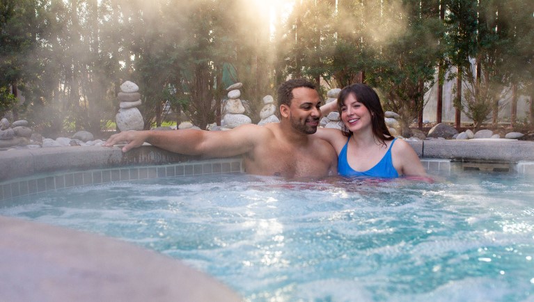 A couple smiles and enjoy in the Outdoor Whirlpool Hot Springs