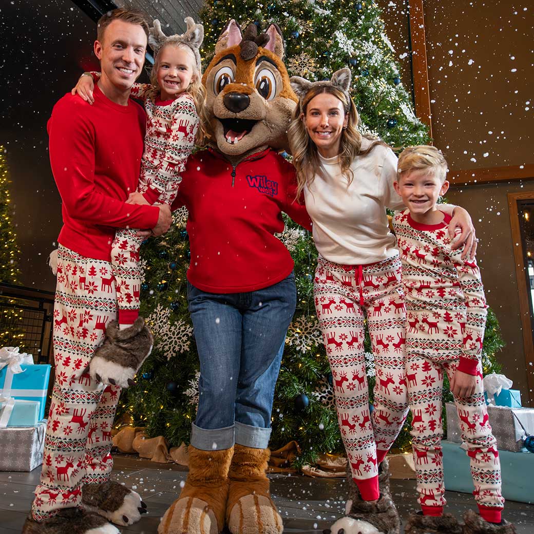 family of four in Holiday pajamas with Wiley the wolf