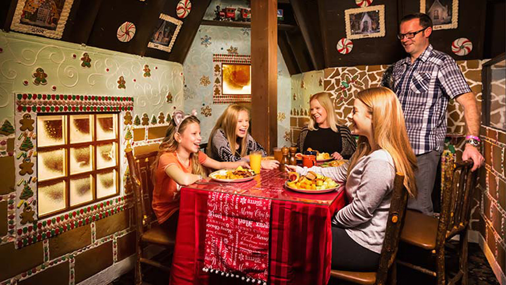 family enjoying food inside the gingerbread house
