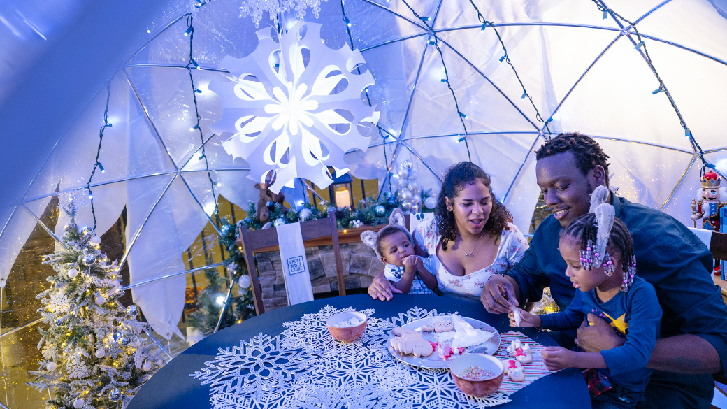 A family of four enjoying time under the snow globe
