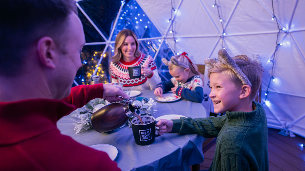 A family of four enjoying time under the snow globe