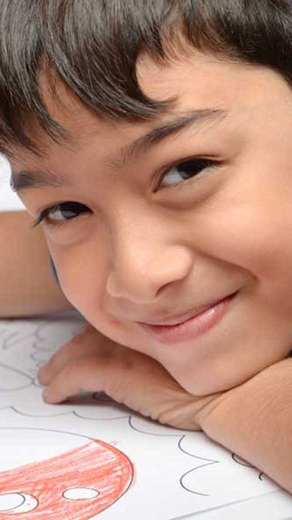 a boy coloring his drawing