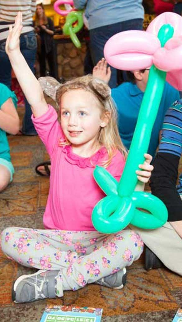 kids sitting in the main lobby with flower balloons playing bingo