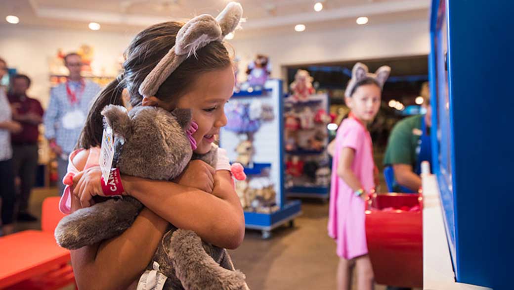 Girl holding her plush toy from Stuffing Station