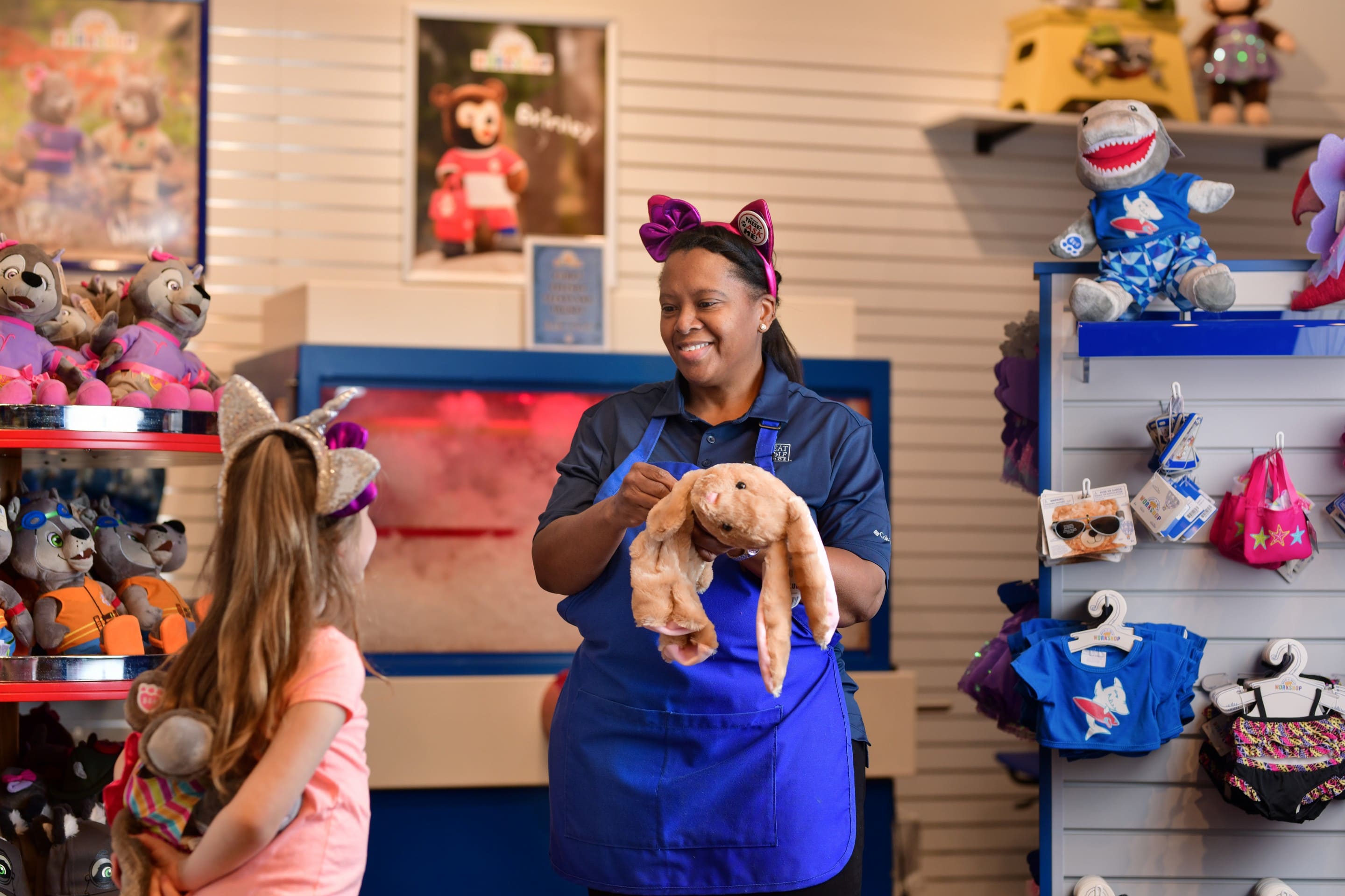 staff member showing a stuff toy to a little girl