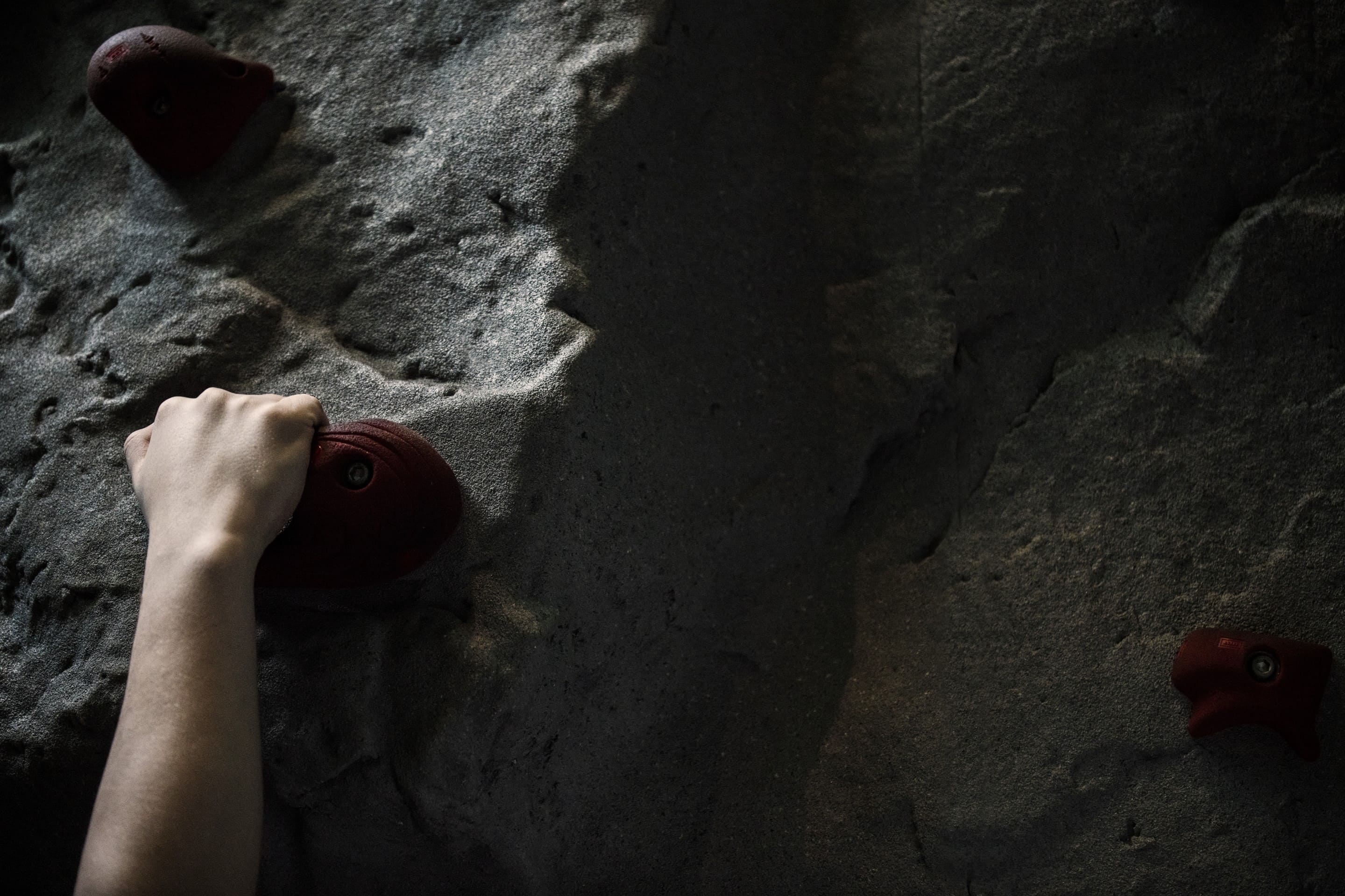 Close-up of hand gripping indoor climbing wall hold