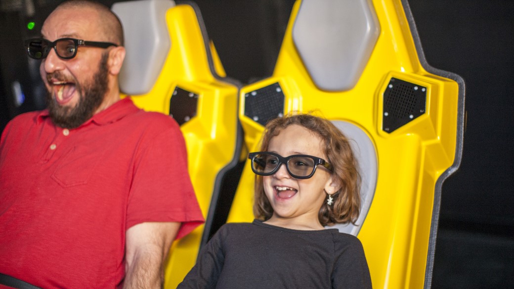 A girl and her dad enjoying a 4D ride