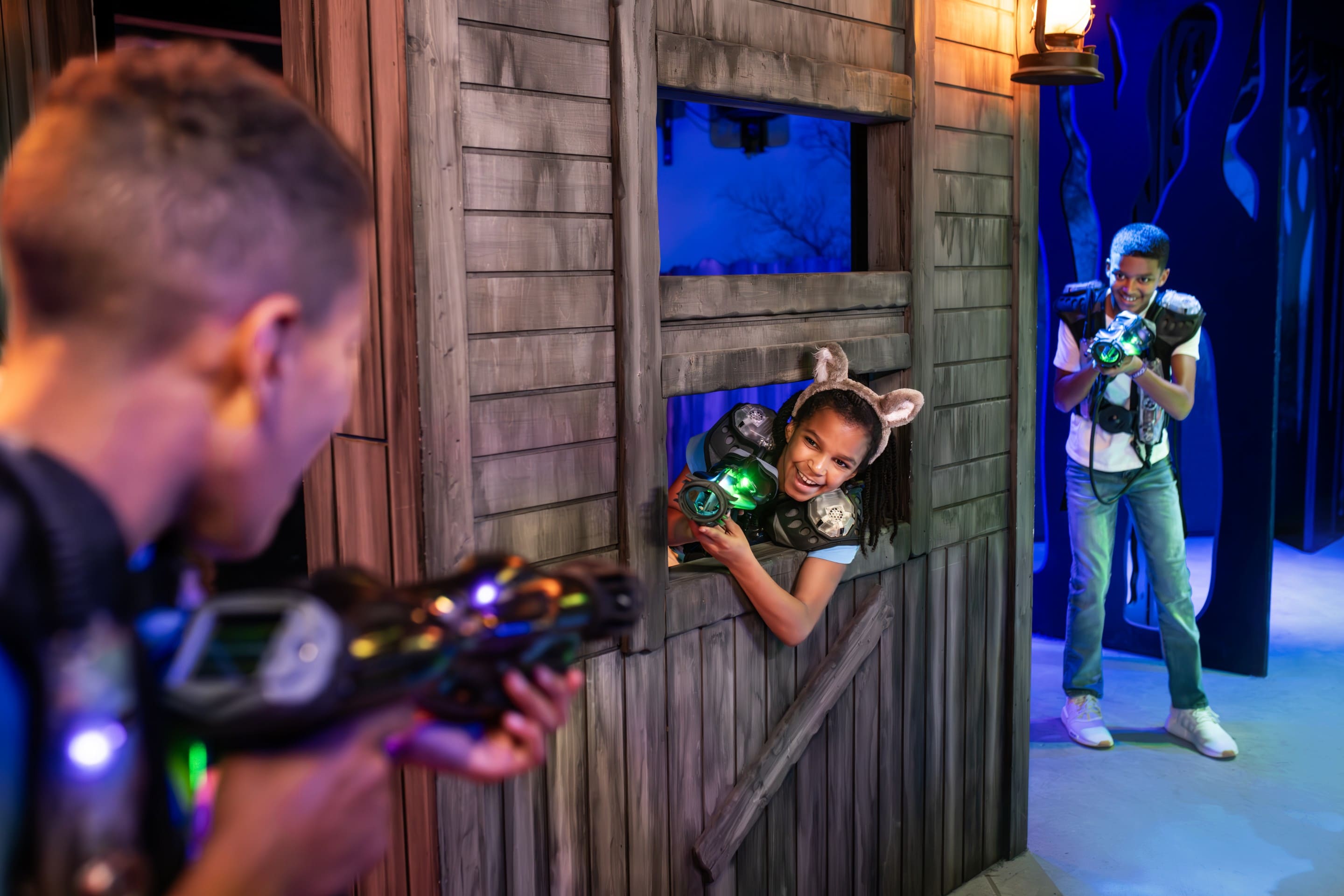 Kids playing laser tag inside themed wooden arena