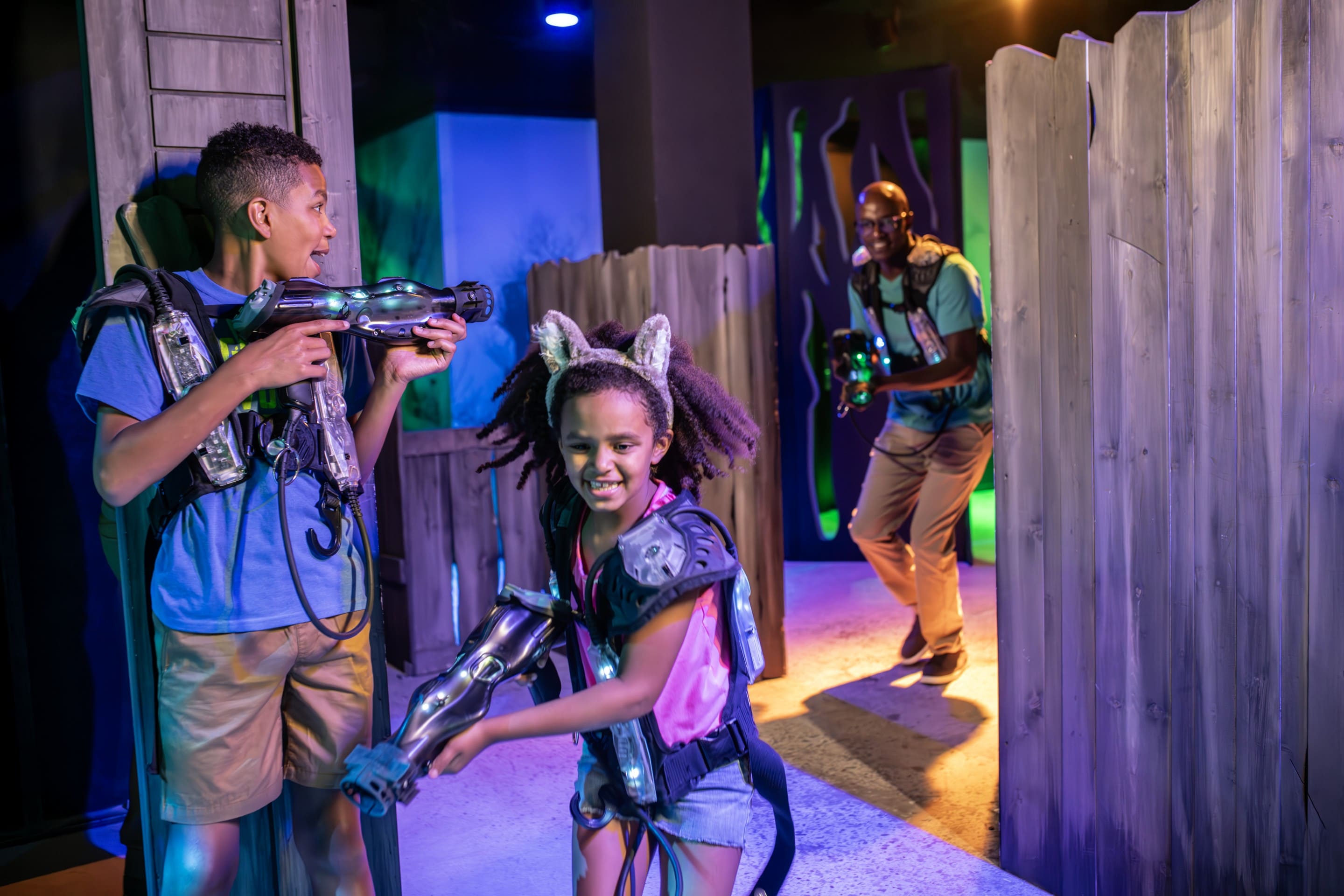 Family laughing and playing laser tag together