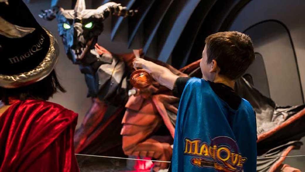 Two kids with a wand play the MagiQuest interactive game at Great Wolf Lodge indoor water park and resort.
