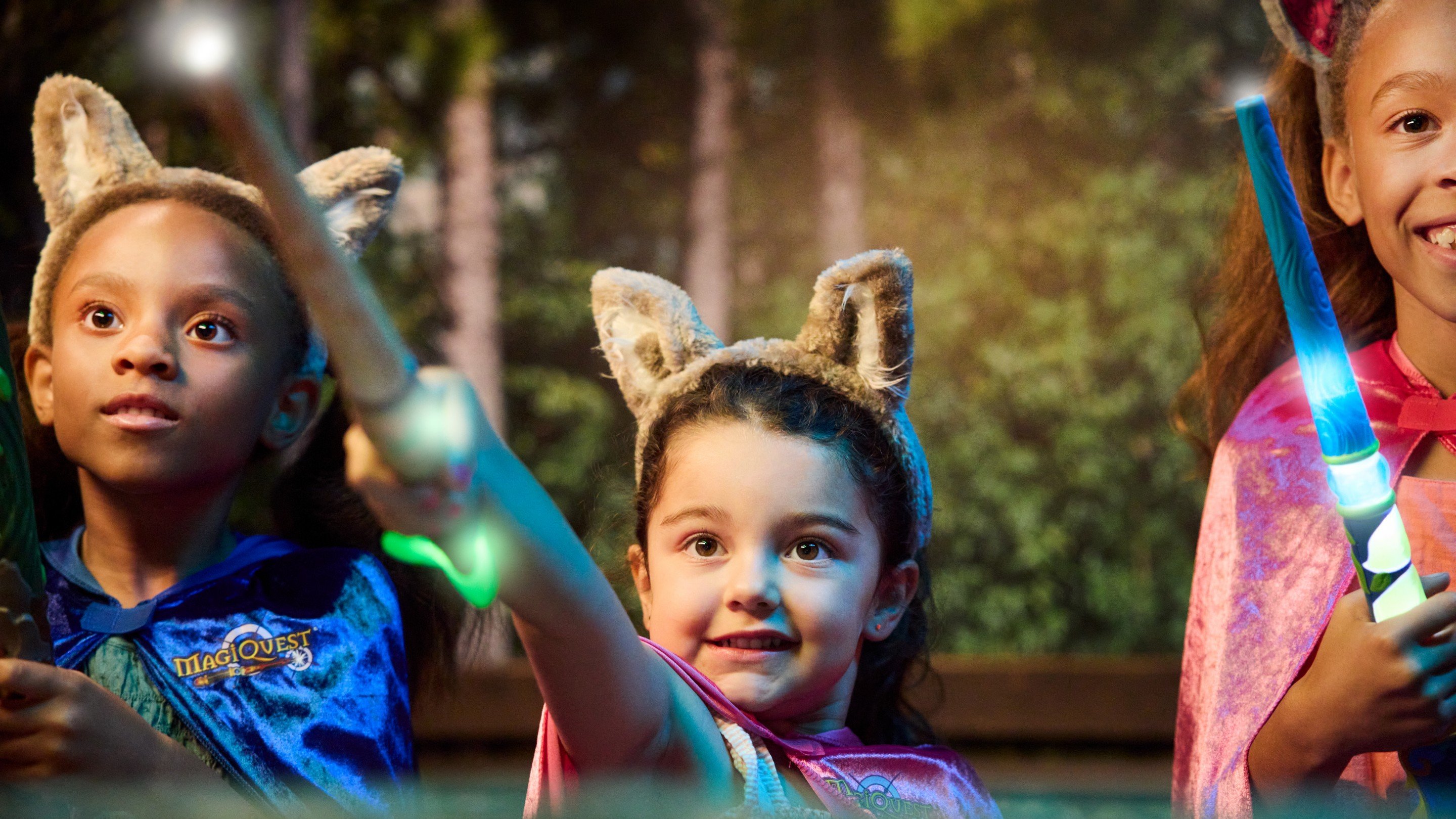 Three children wearing wolf ears holding magic wands.