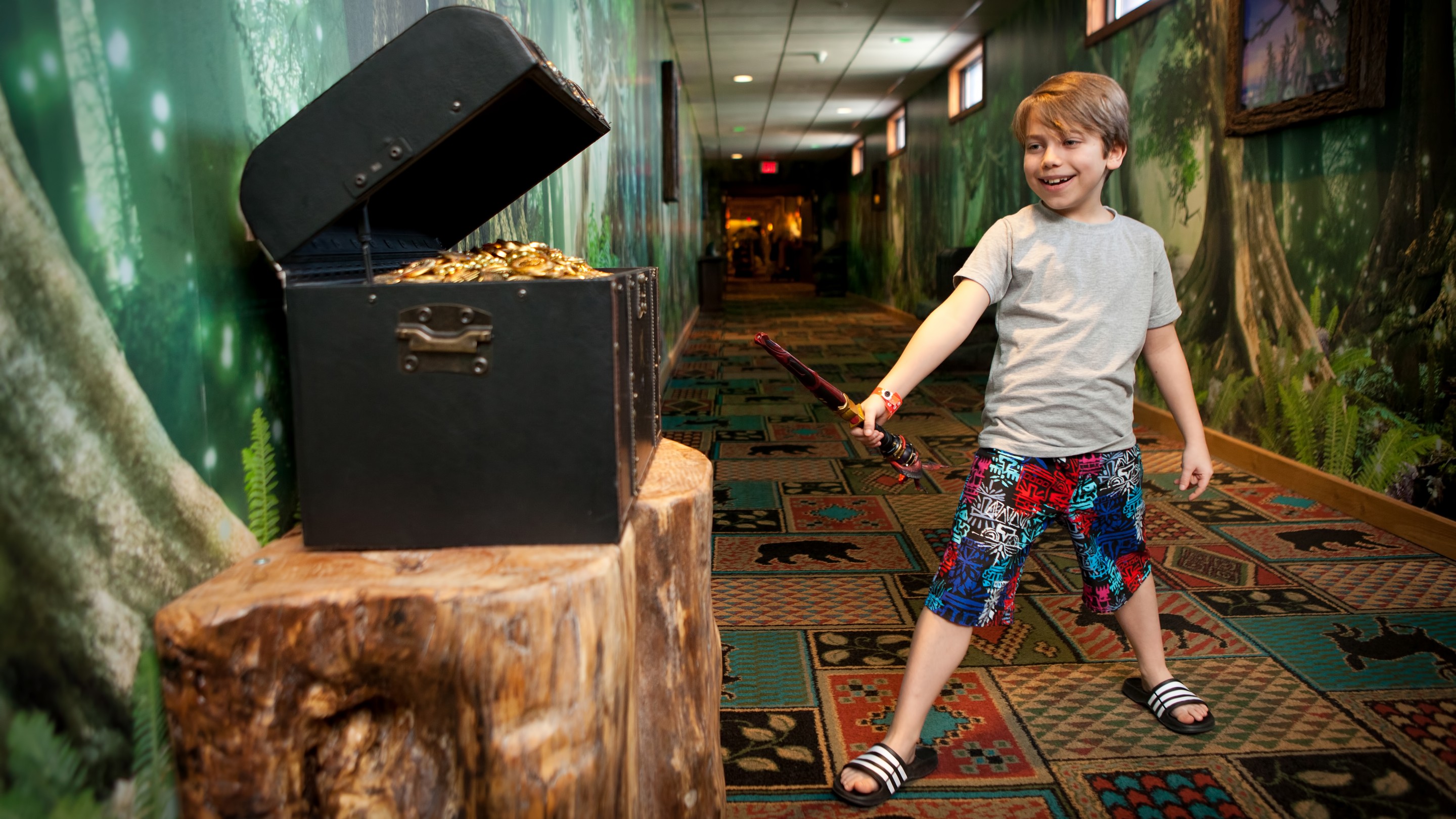 A little boy using his magic want to open a treasure chest full of gold coins.
