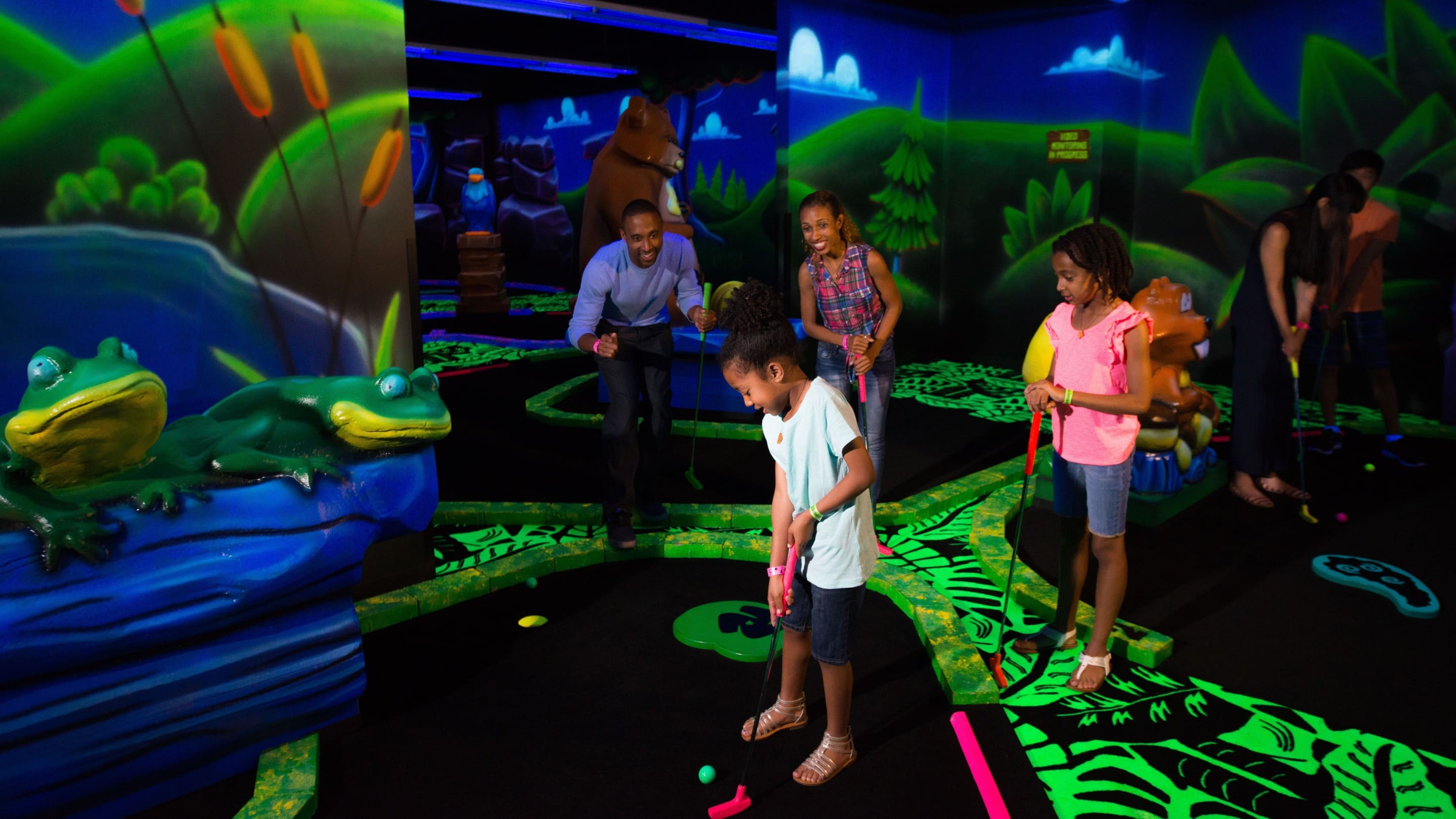 Family looking on as the son putts