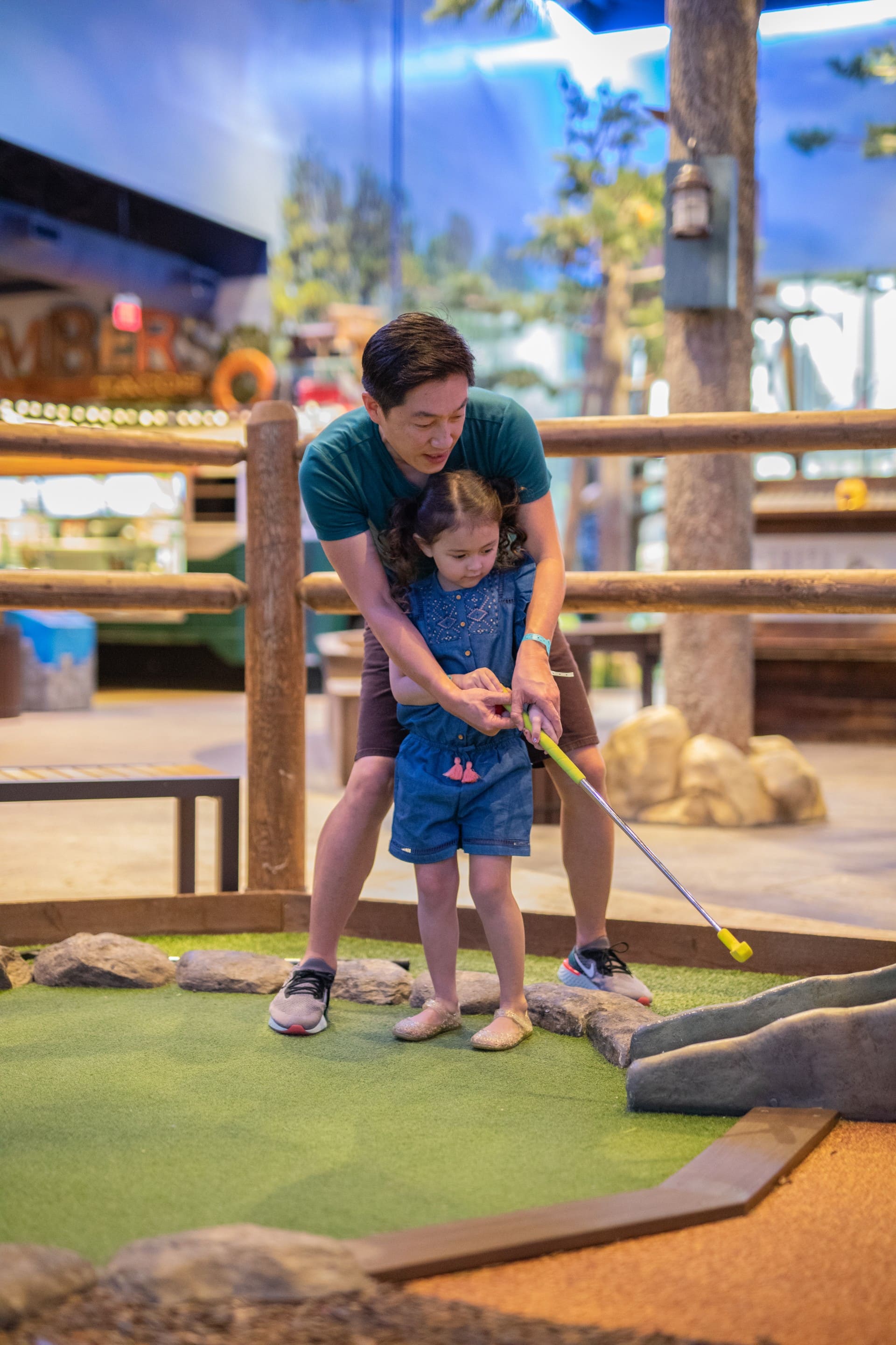 Father teaching her daughter how to play