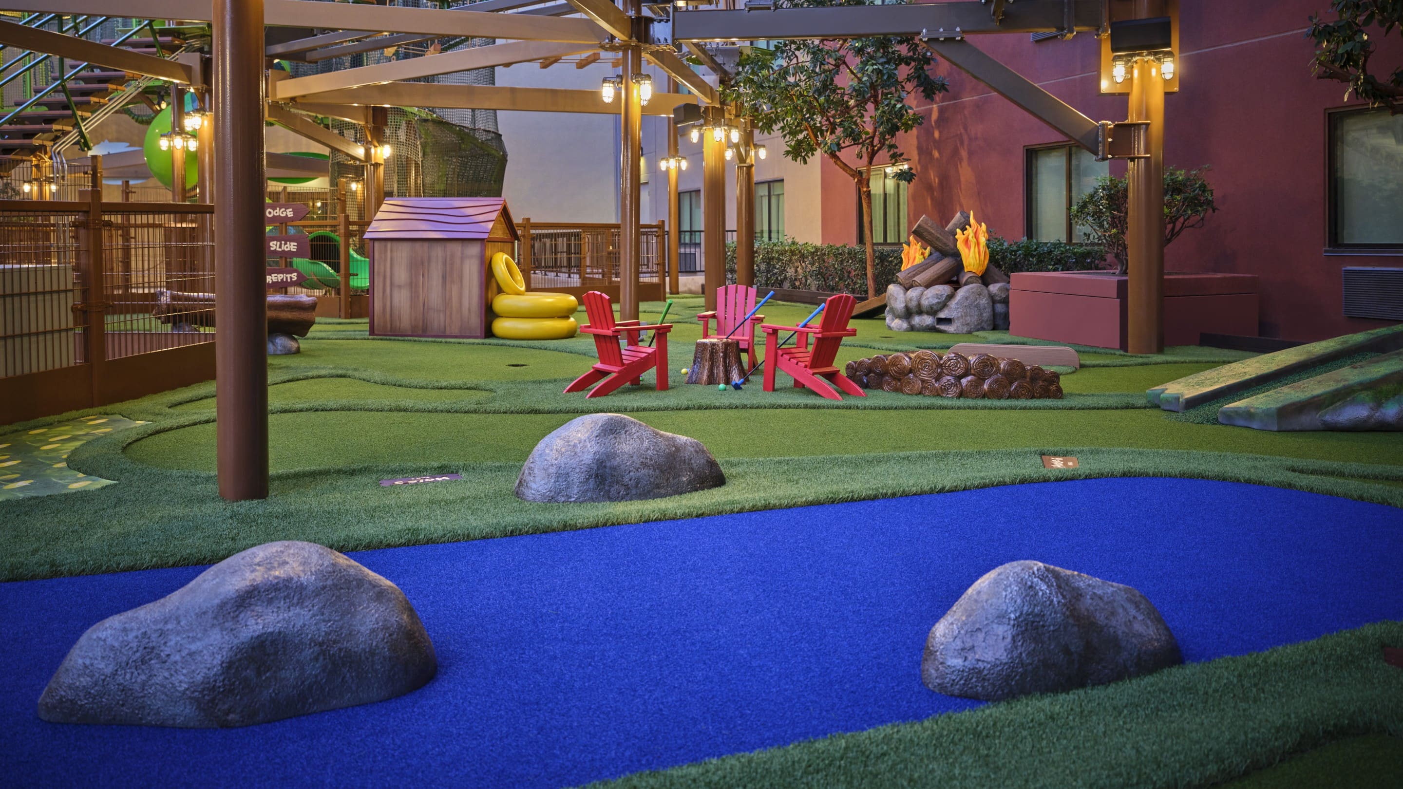Mini golf course with seating and campfire setup