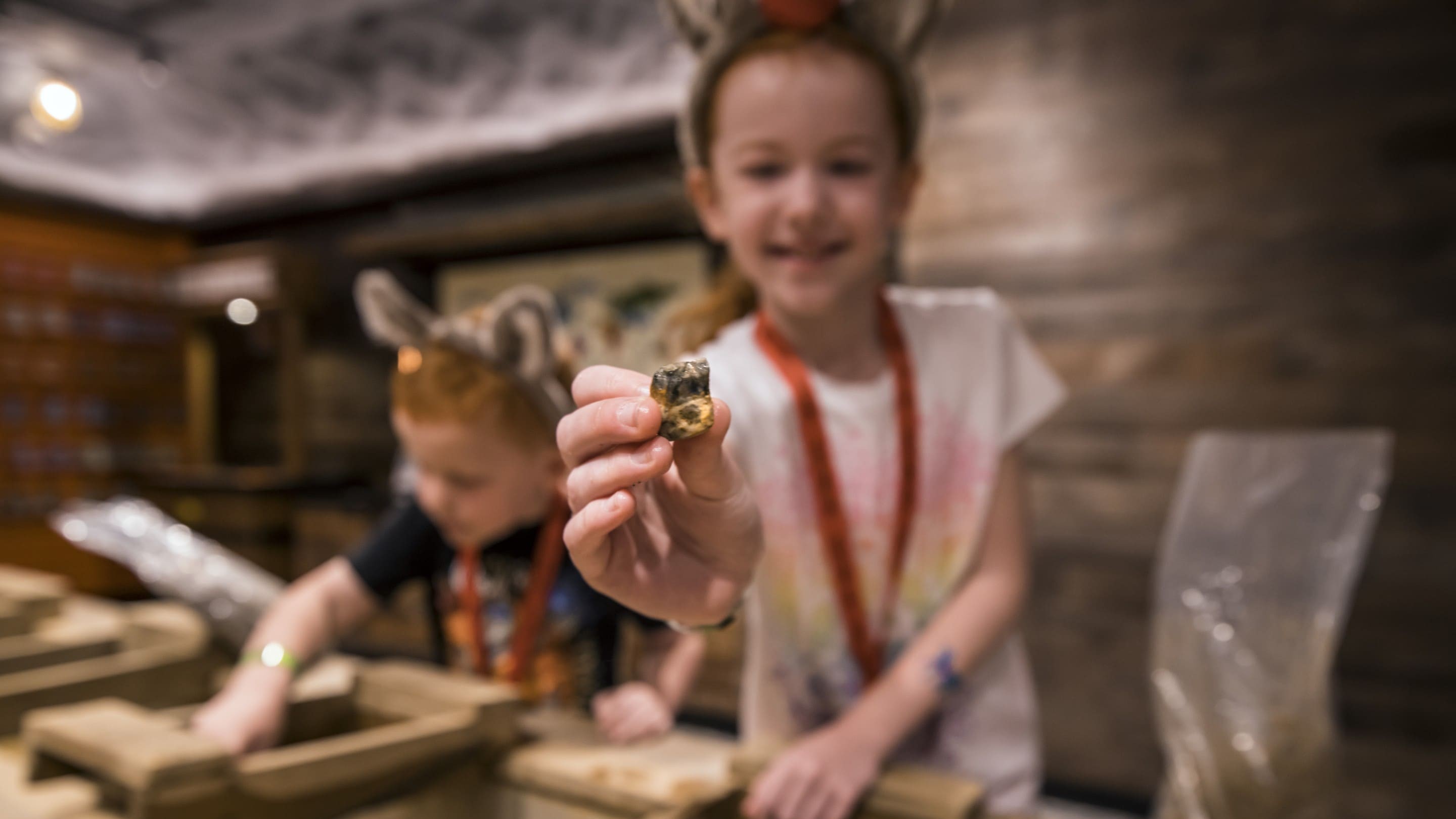 Smiling child shows gemstone at mining station