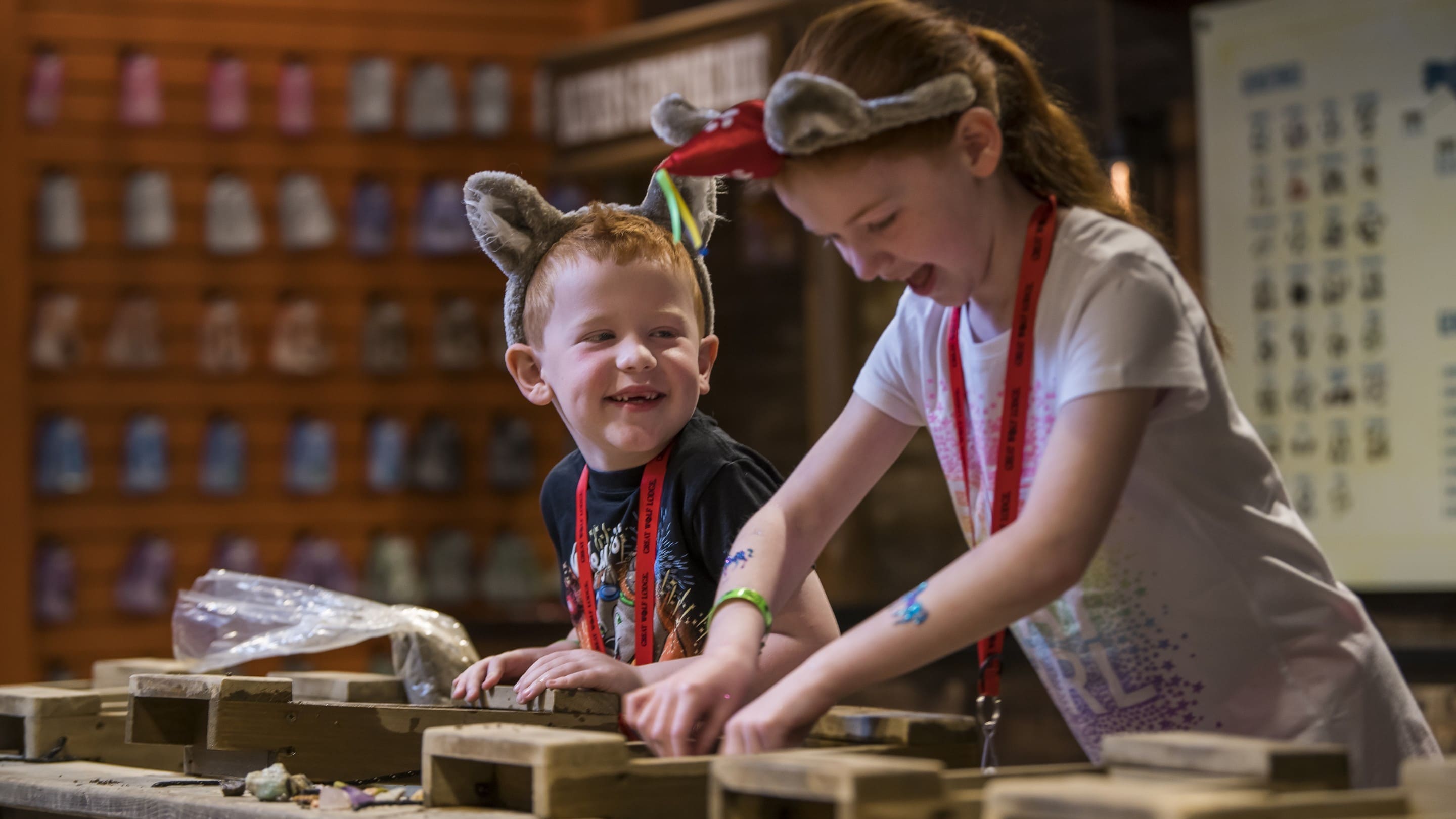 Two smiling kids gem mining together indoors