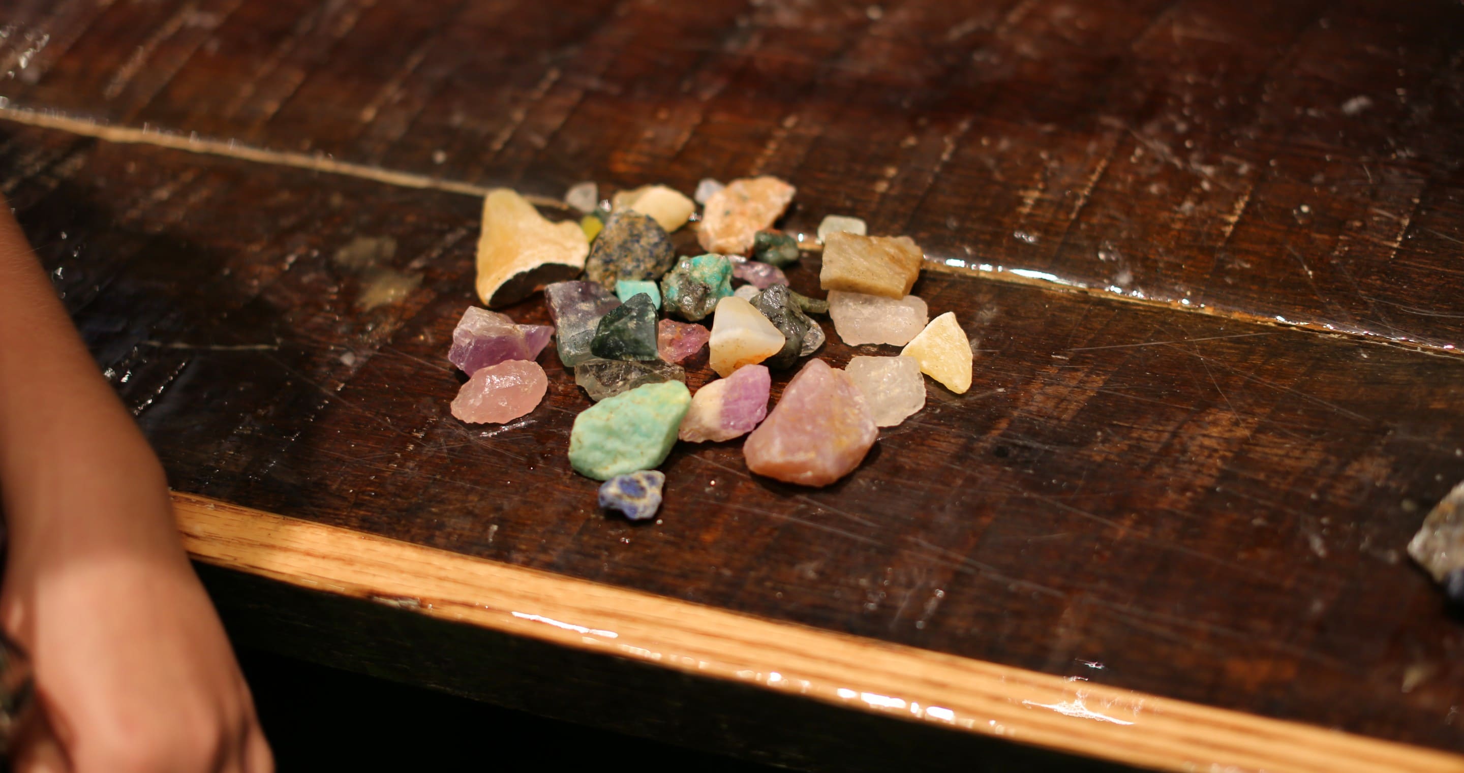 Pile of colorful gemstones on wooden table