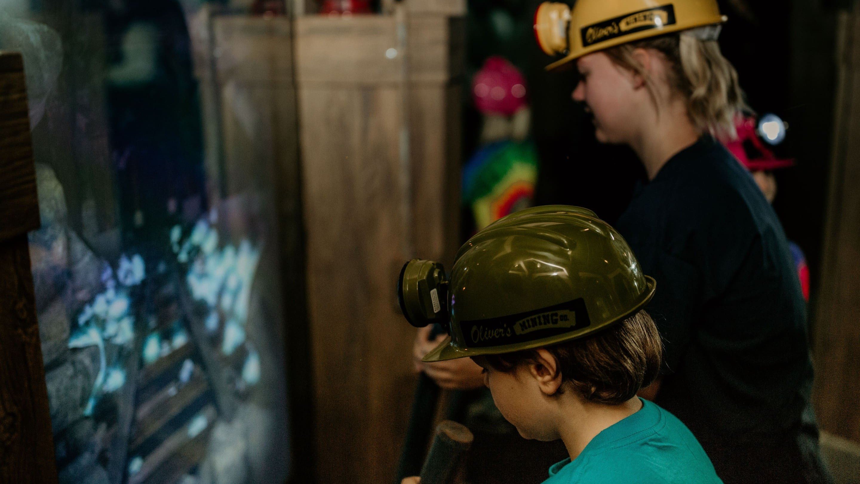 Children wearing mining helmets exploring a virtual display