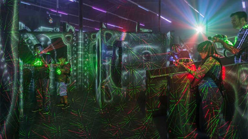 Adults and kids playing laser tag