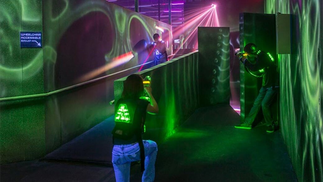 girl hiding while playing laser tag