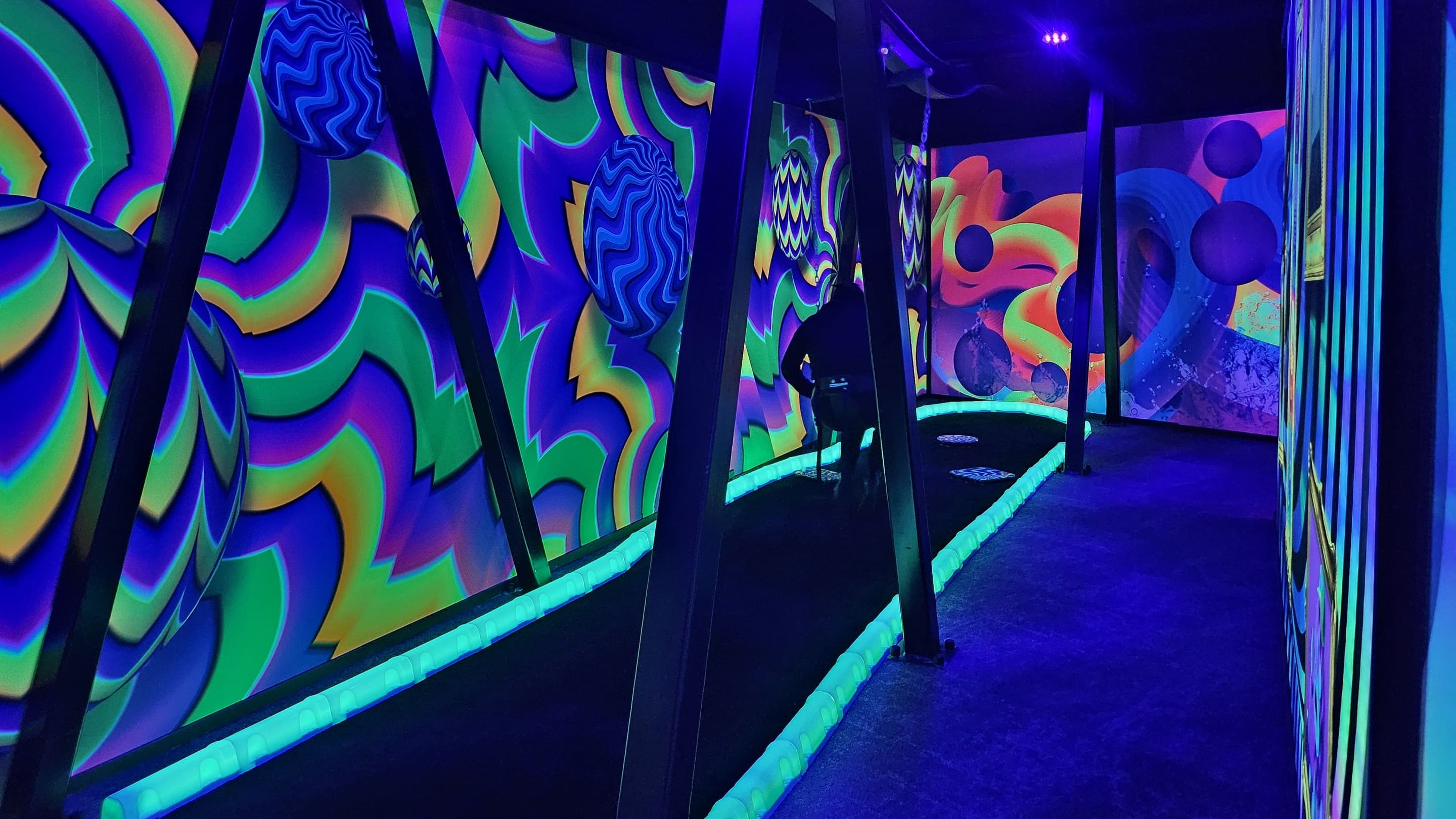 Vibrant, neon-colored walls in mini golf course