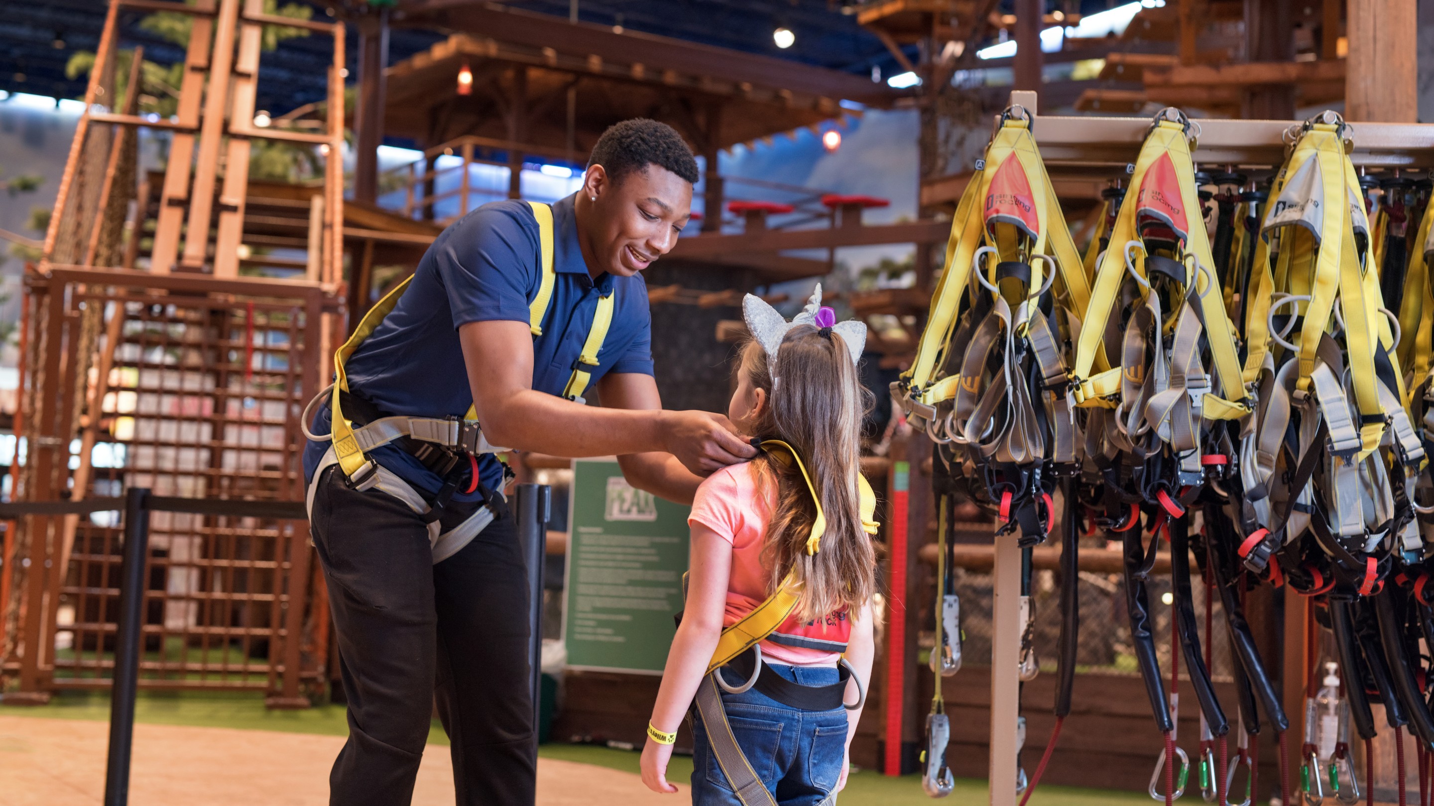 Staff member helping child adjust safety harness