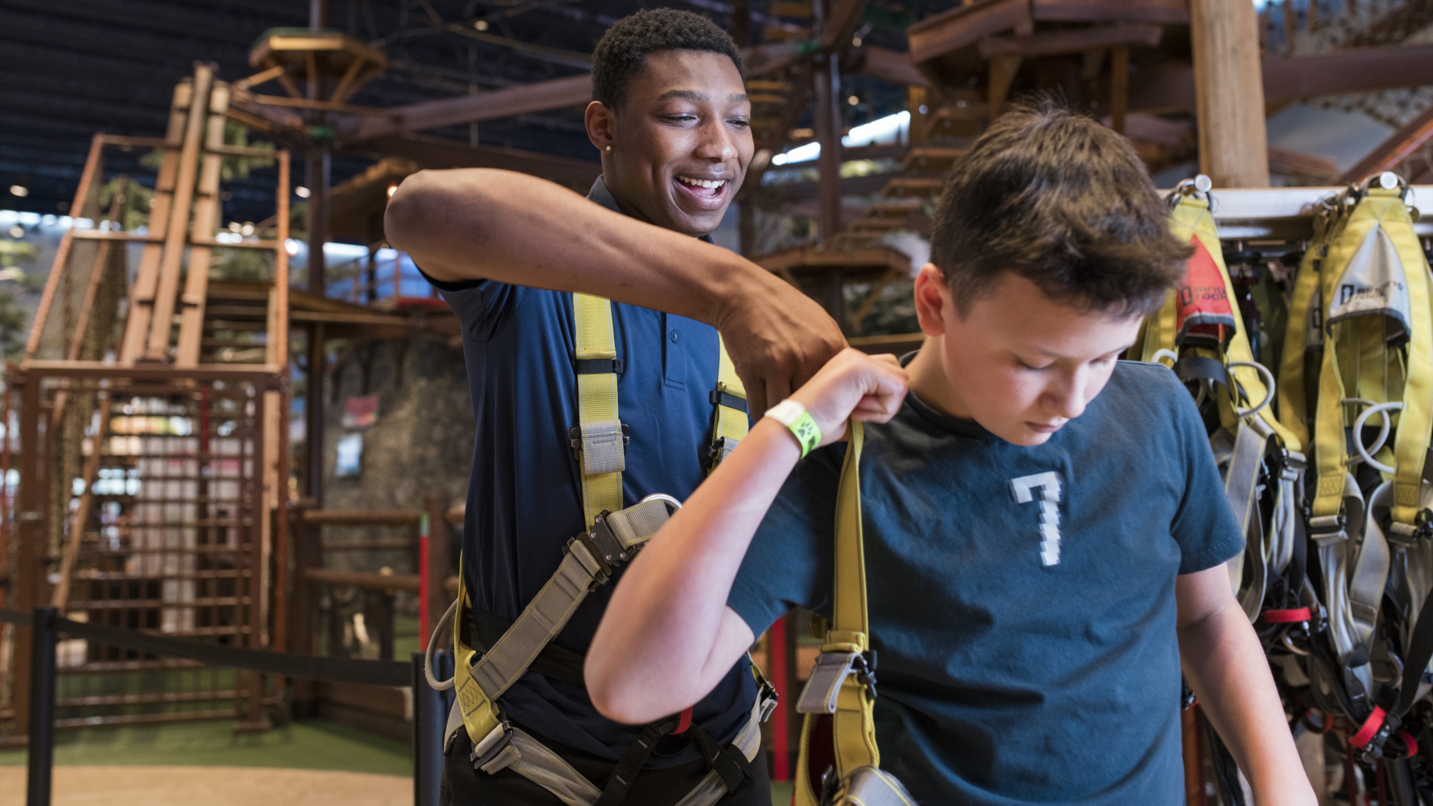 Staff member helping child to put on the safety harness