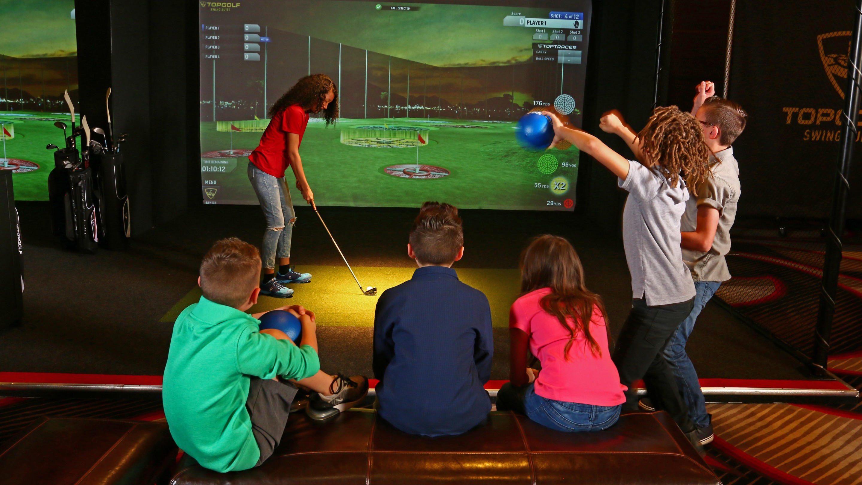 Kids playing virtual golf at simulator
