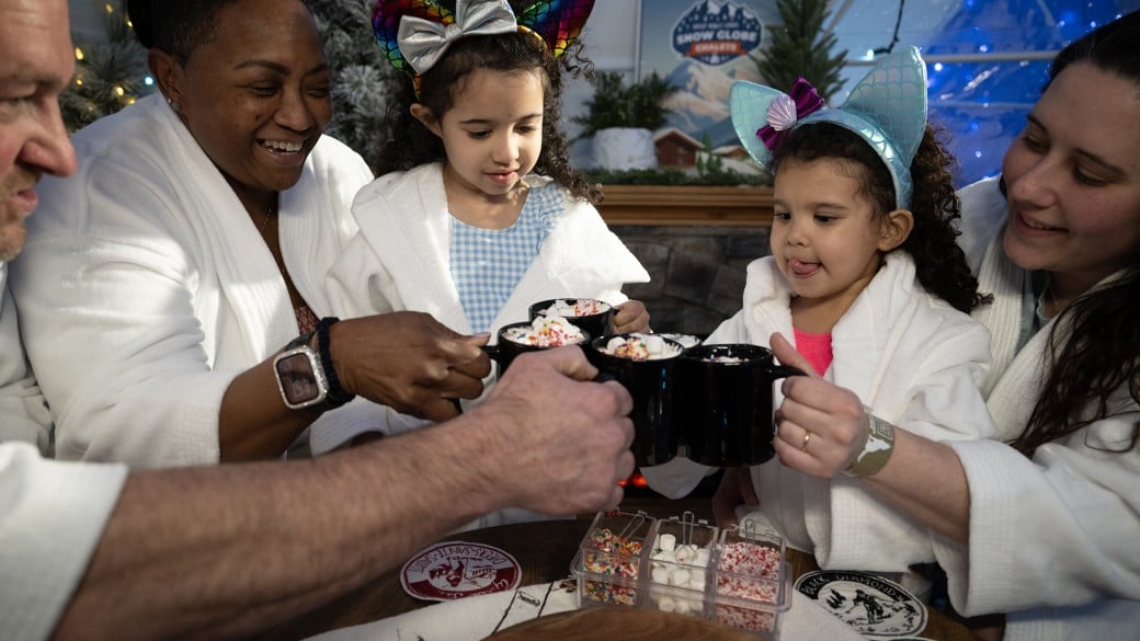 Family enjoying hot chocolate at snow globe