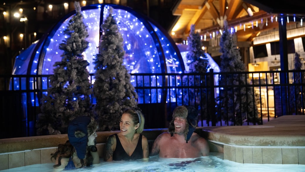 Couple enjoying hot bath at snow globe chalets
