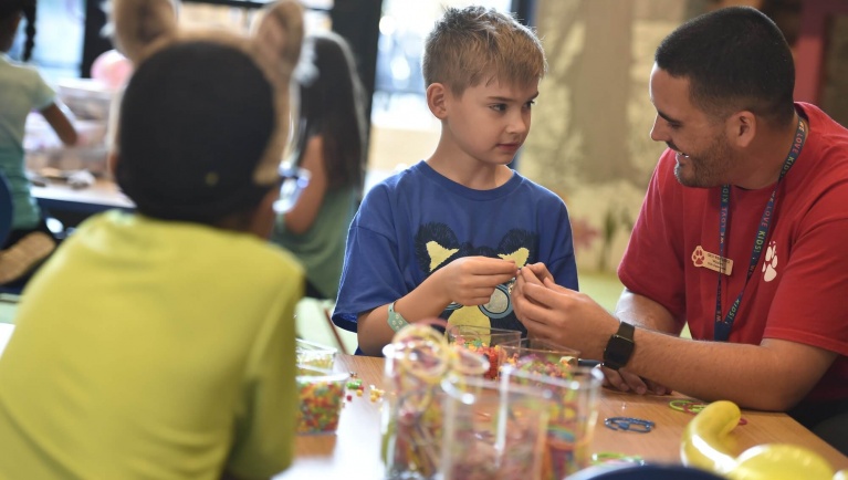 A child in wolf ears working on an arts & crafts project