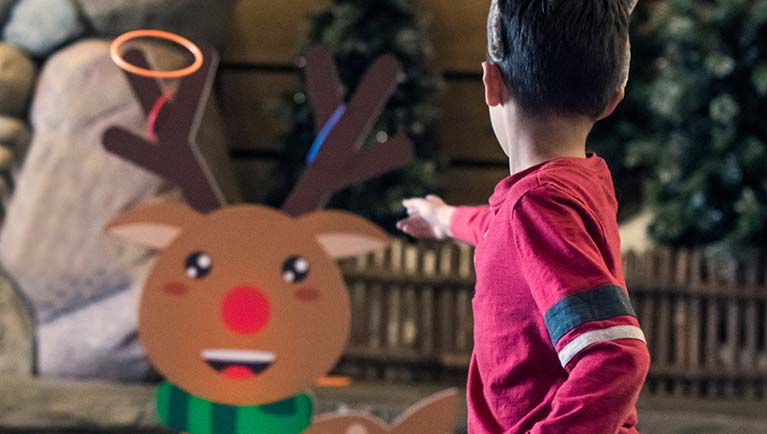 young boy playing reindeer ring toss