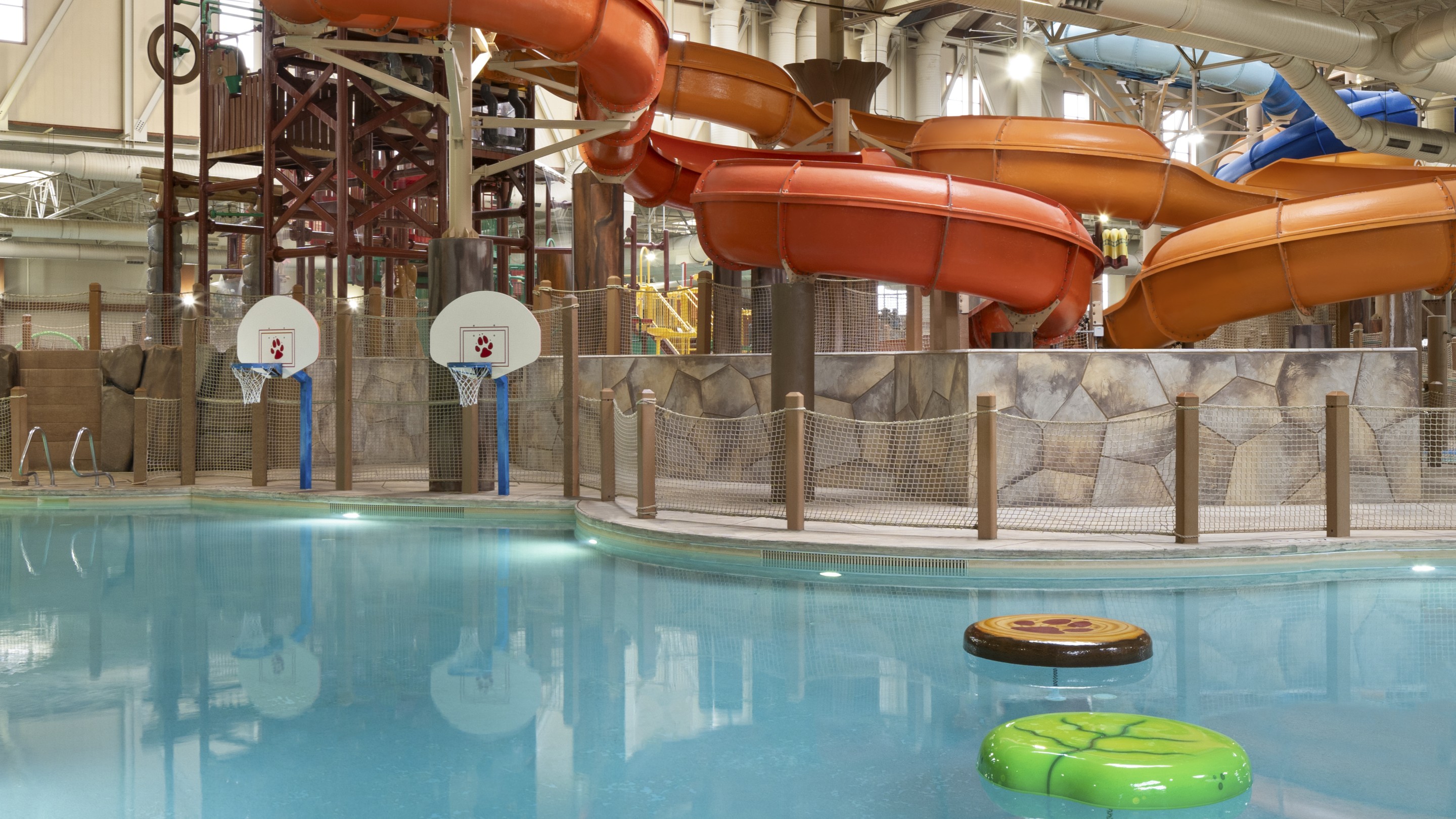 A massive water slide curves down into a lively indoor pool, perfect for splashes and laughter on a fun day.