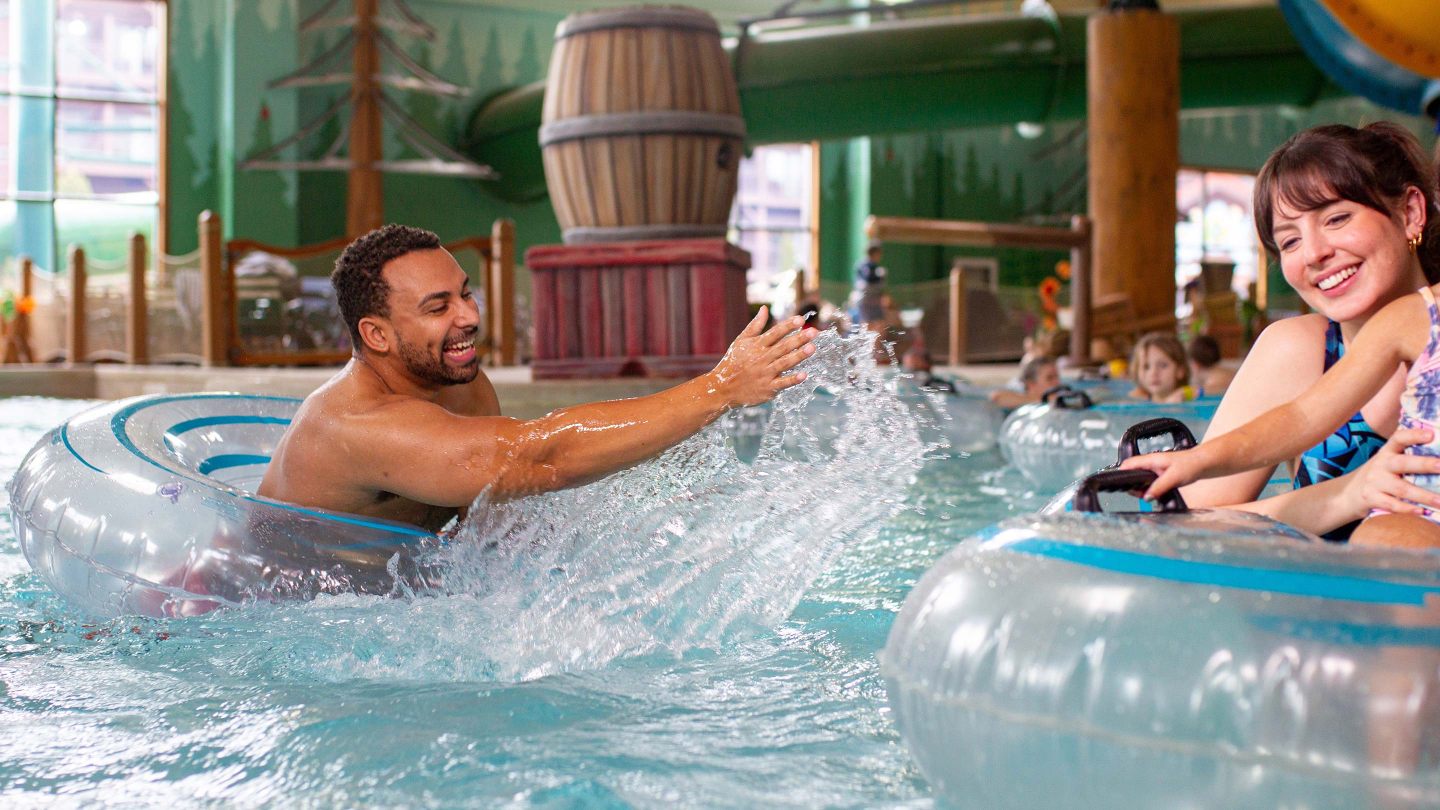 father splashing some water to his wife and daughter