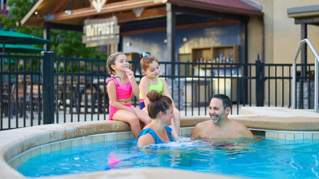 family of four enjoying the outdoor hot tub