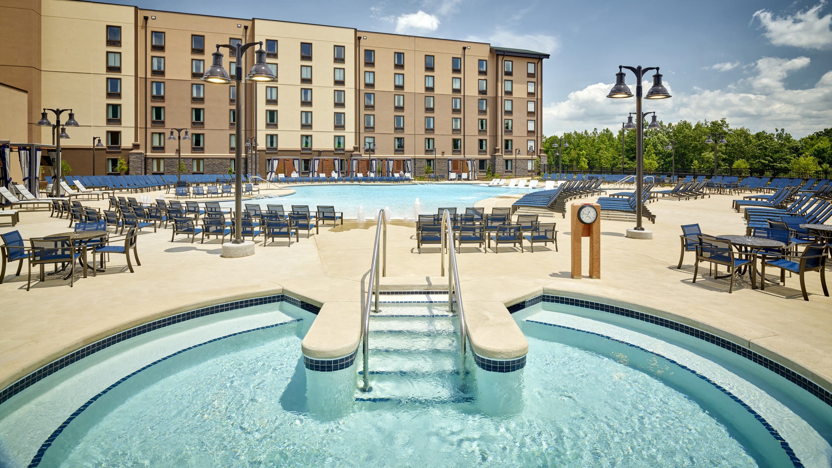 view of an outdoor hot tub with a outdoor pool in the background