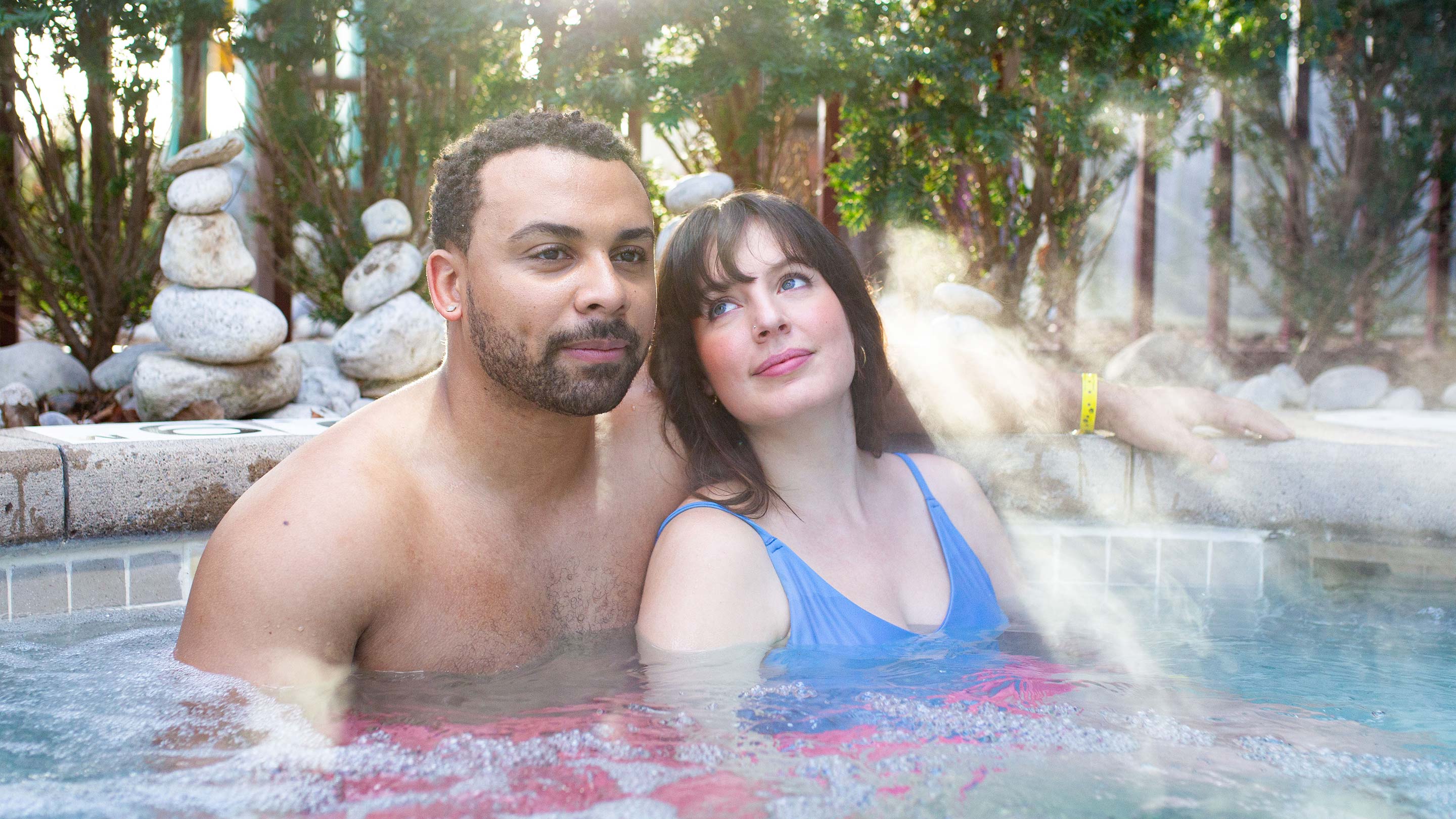 A couple relaxes in an outdoor hot tub