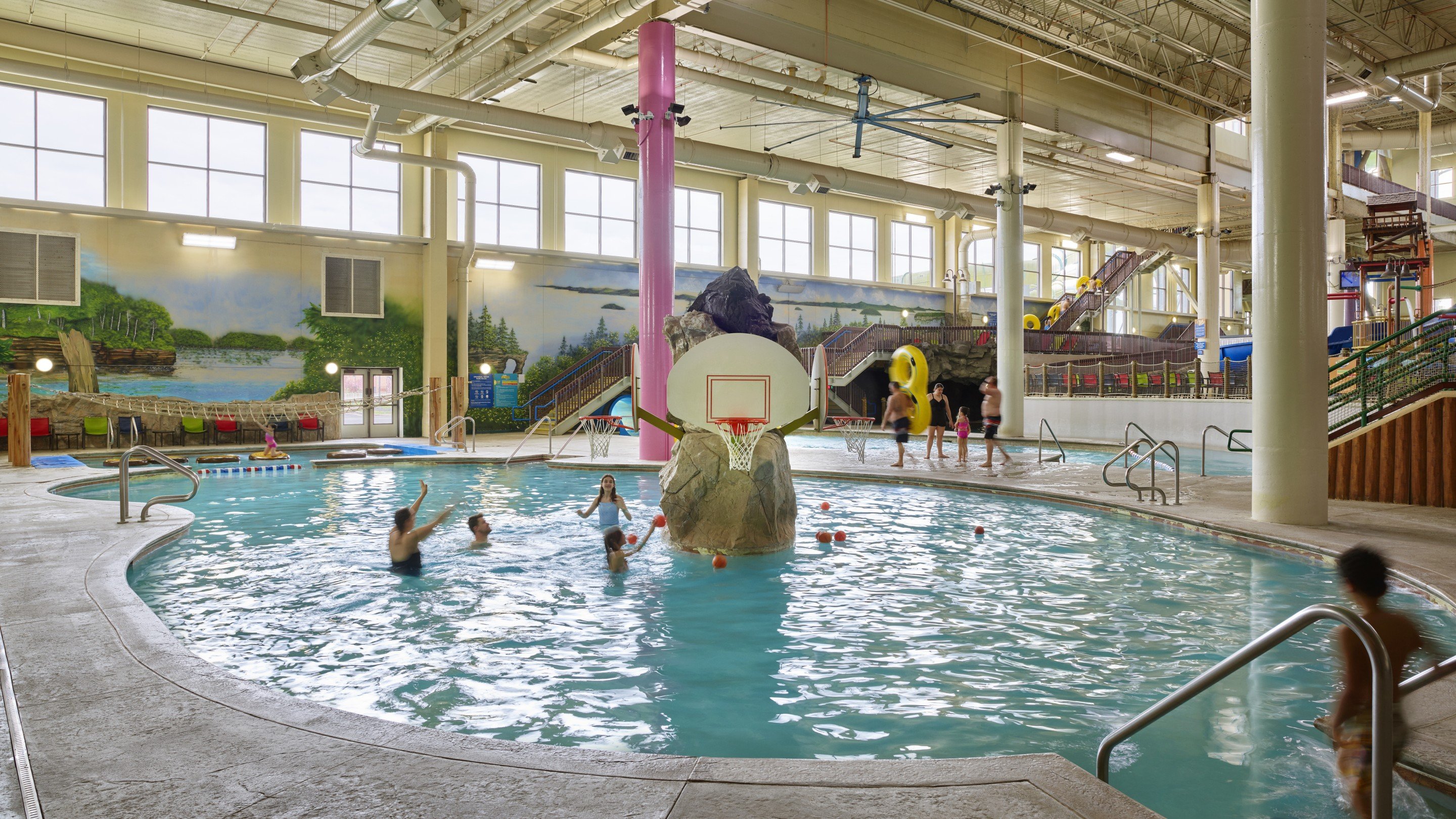 Family playing basketball in indoor pool
