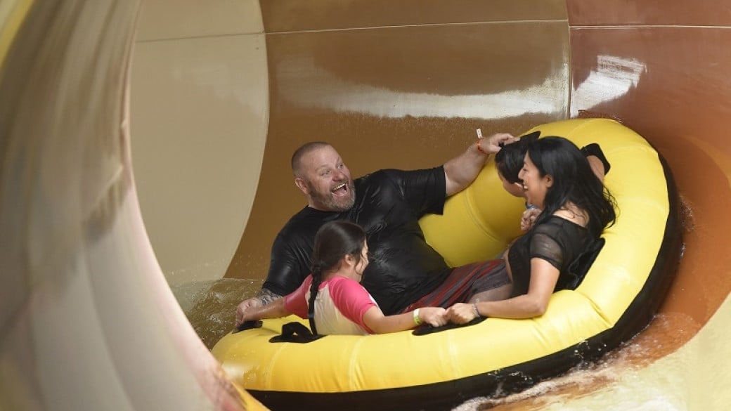 A family rides the Diamond Back Drop water slide