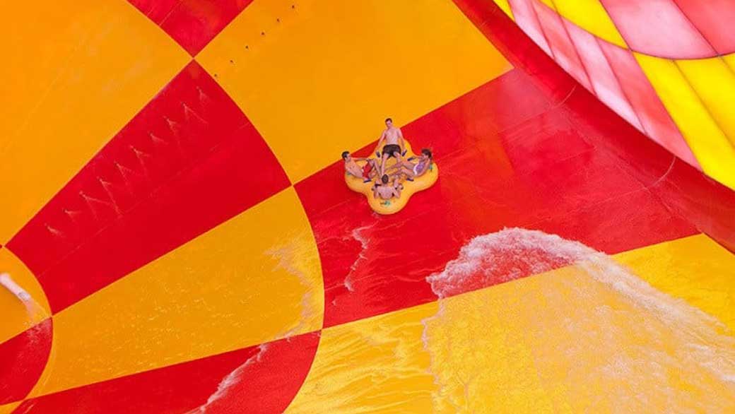 A family of four ride a tube down the Howlin' Tornado water slide