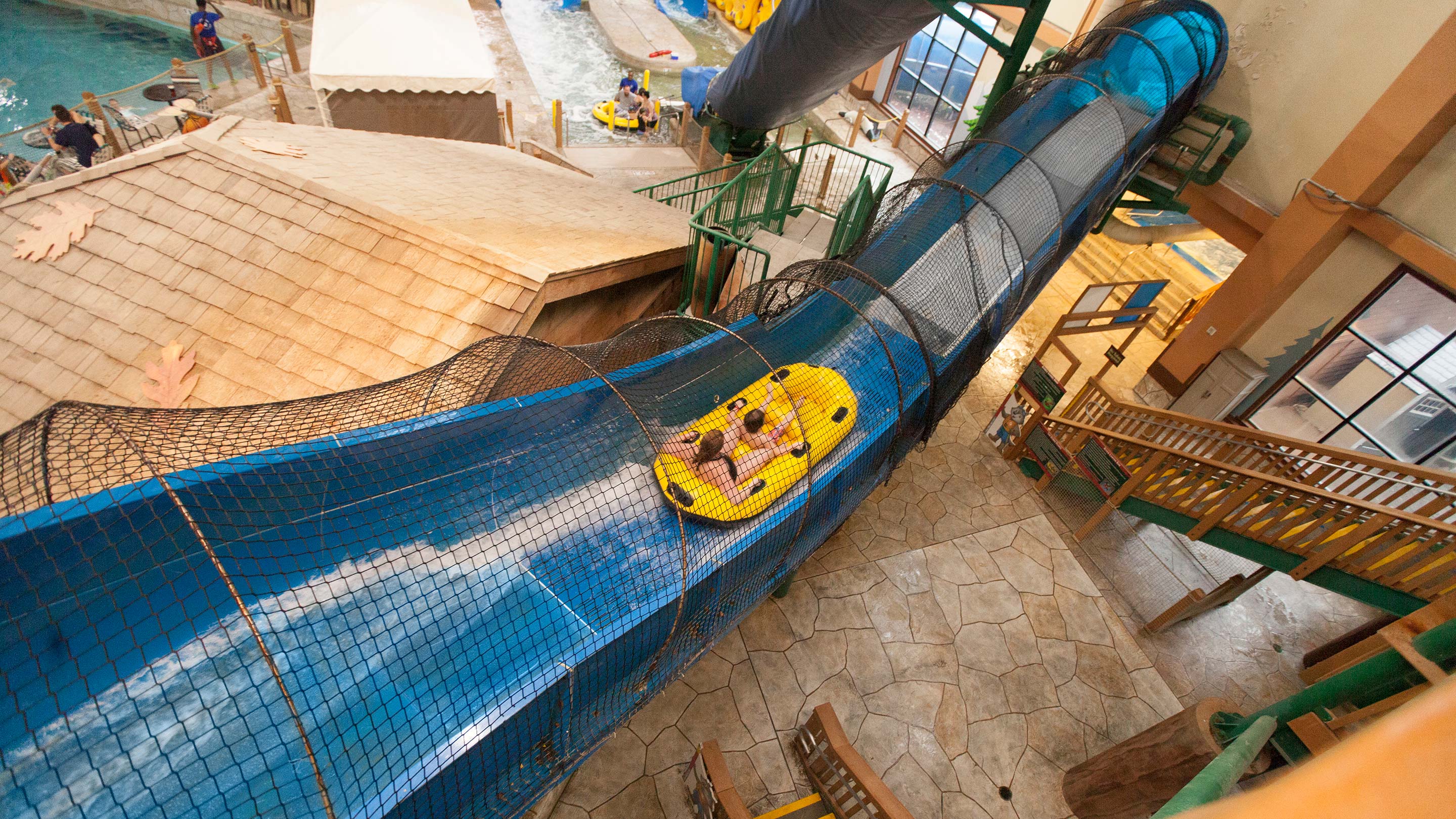 view of the indoor water park with a yellow and blue slide 