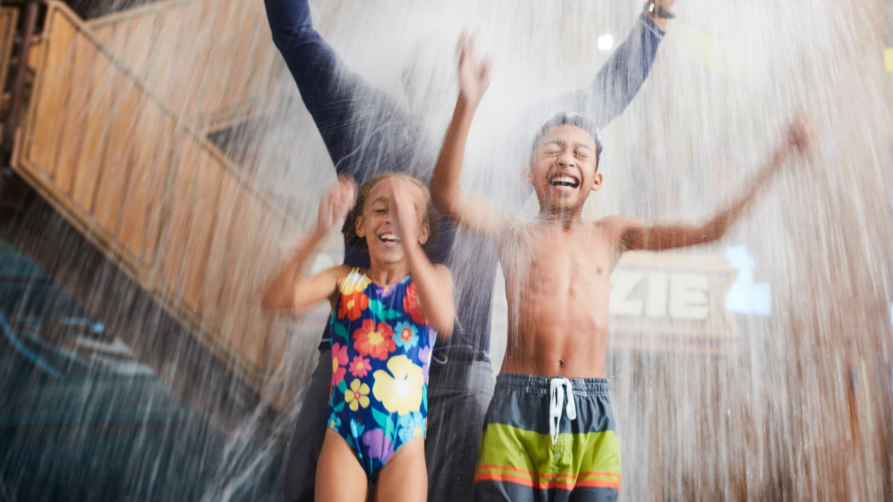father and two kids being splashed by water