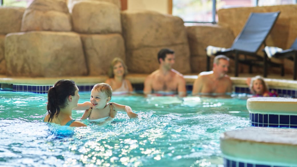 Mother holding her son in a pool