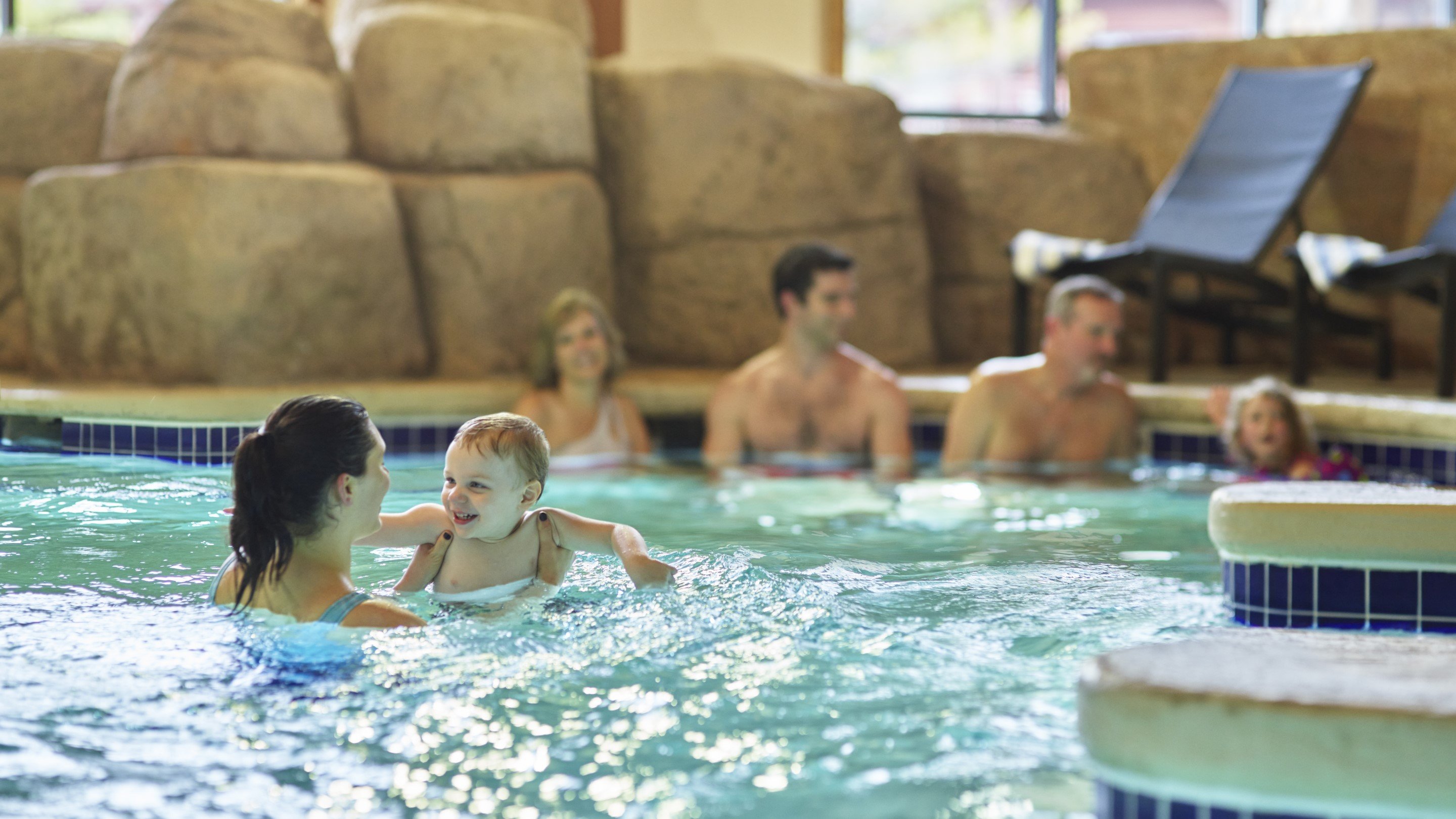 family relaxes in an indoor hot tub