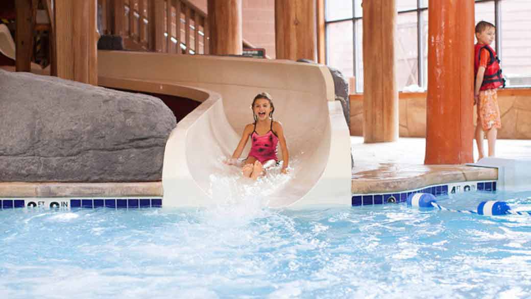 A girl smiles as she rides the Mineshaft water slide