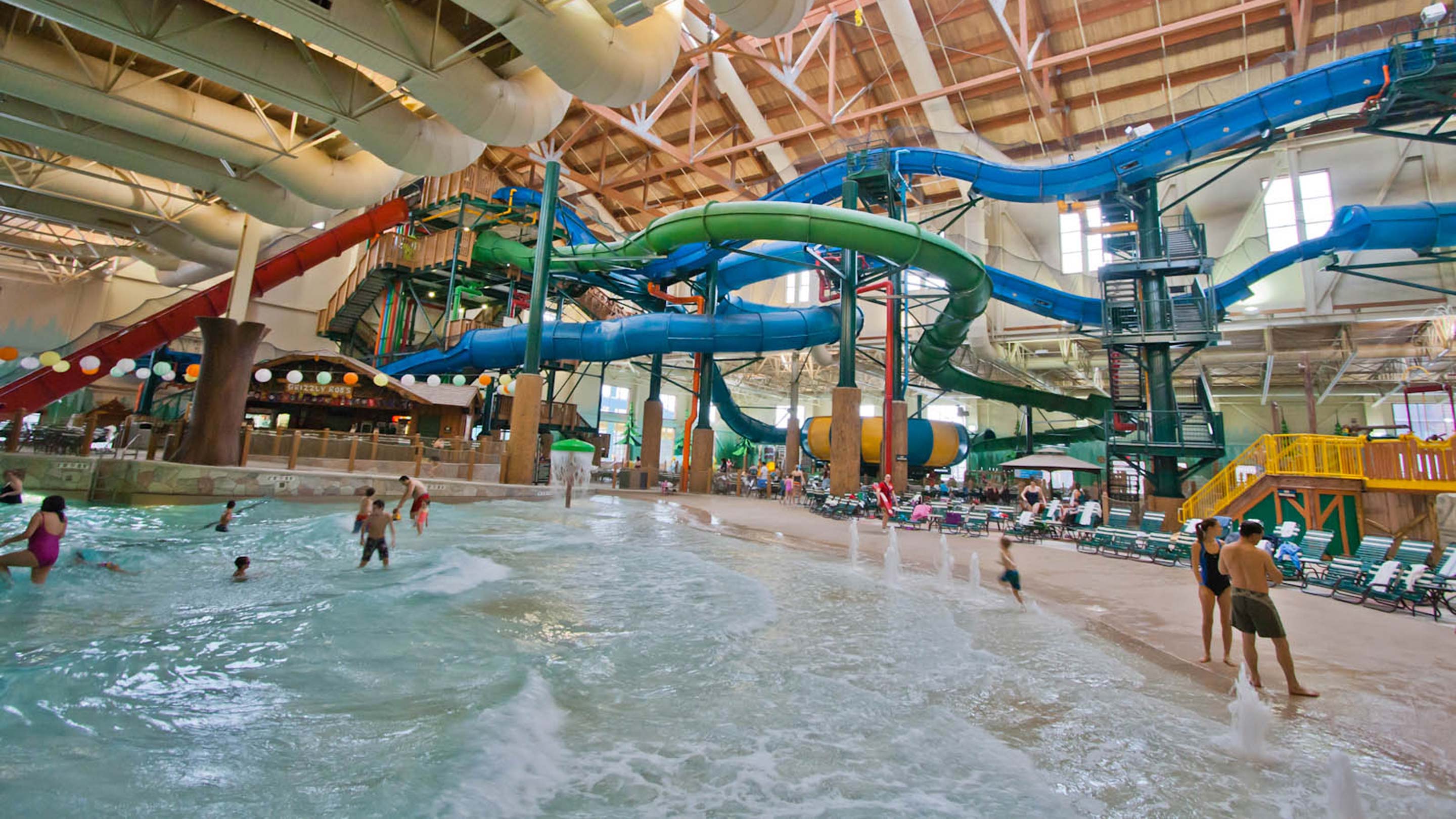 Visitors playing in the wave pool beneath the water slides.