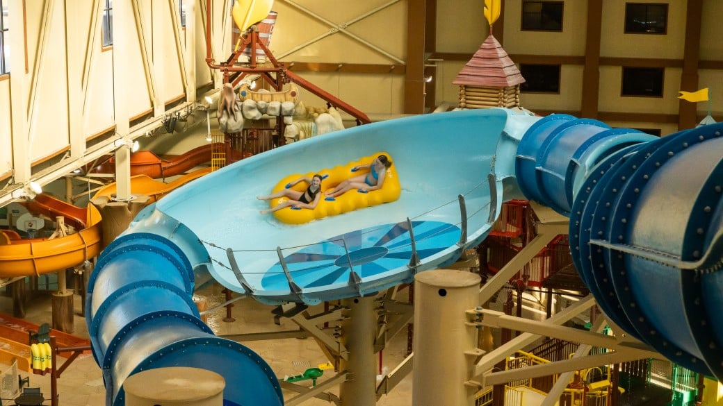 two girls ride a  tube down the river racer water slide